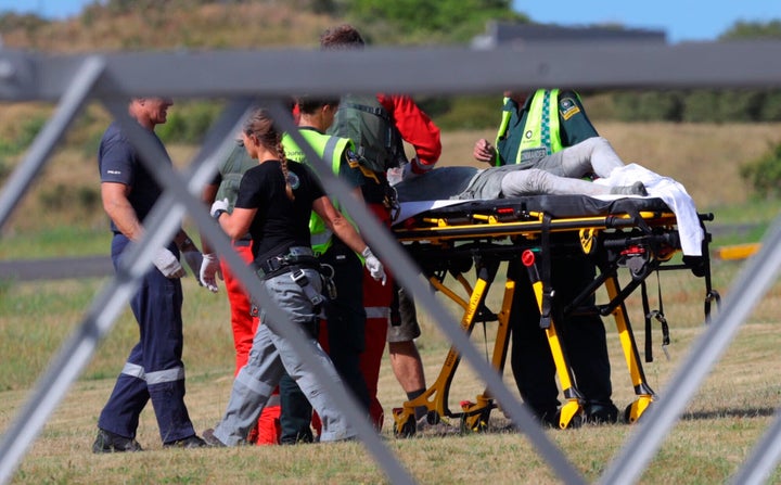 Emergency services attend to an injured person arriving at the Whakatane Airfield after the volcanic eruption on Monday.