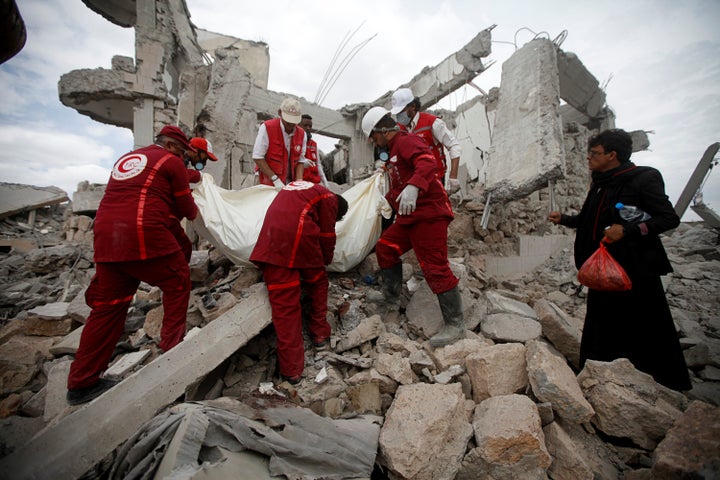 Red Crescent medics remove the body of a victim of Saudi-led airstrikes on a Houthi detention center in Dhamar, Yemen, on Sept. 1, 2019.