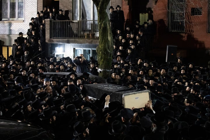 Orthodox Jewish men carry Moshe Deutsch's casket outside a Brooklyn synagogue following his funeral, Wednesday, Dec. 11, 2019 in New York. (AP Photo/Mark Lennihan)