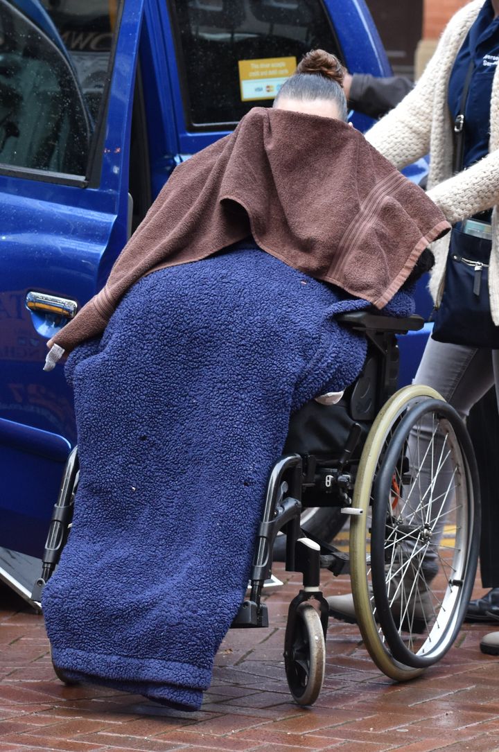 Kathleen Salmond covers her face with a towel as she arrives at Birmingham Crown Court