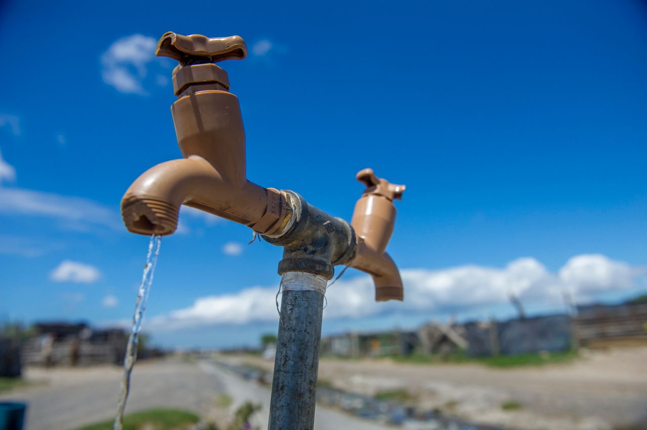 A communal tap runs for people in an informal settlement near Cape Town, South Africa, in January 2018. While the city urged residents to restrict water usage, many living in poor areas already had limited access to water.