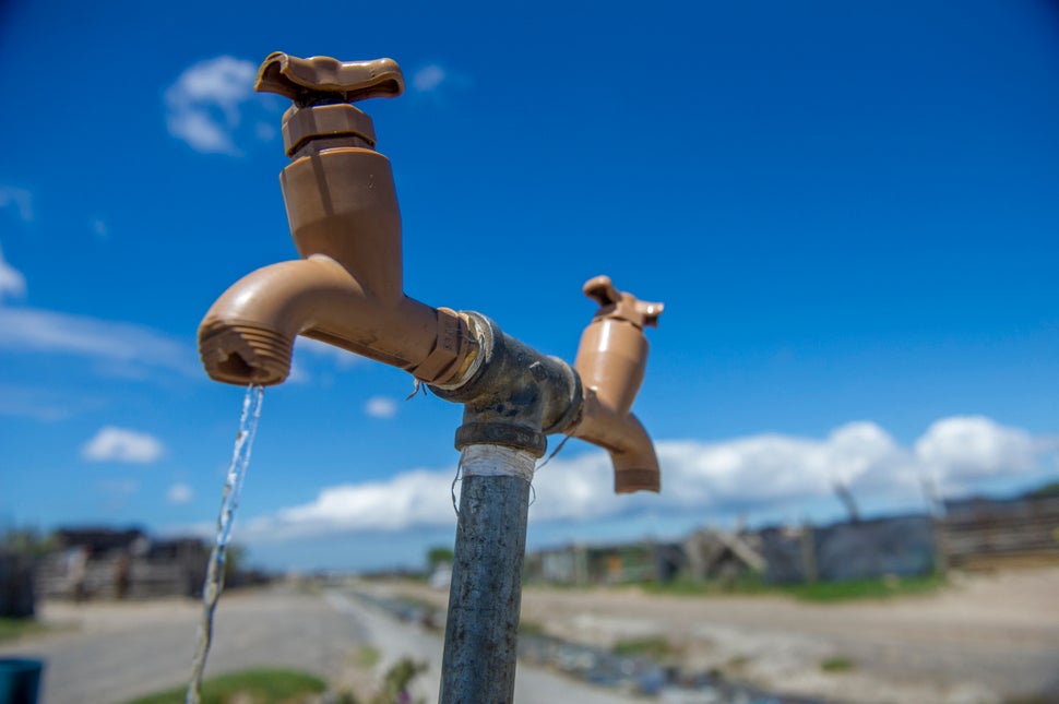 A communal tap runs for people in an informal settlement near Cape Town, South Africa, in January 2018. While the city urged