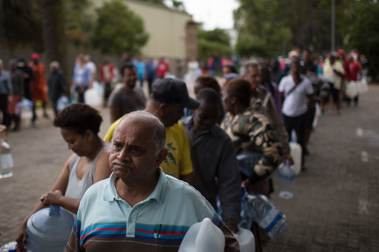 Residents wait to fill containers with water at a natural spring water source in Cape Town in February 2018. People were asked to use no more than 50 liters of water daily.