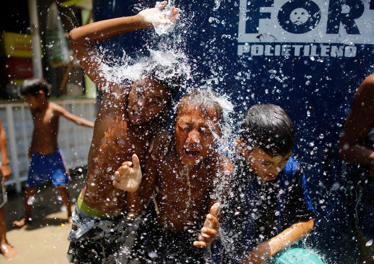 Children play under the water from a water tank at the Alemao Complex neighborhood in Rio de Janeiro in January 2015. According to state environment secretary Andre Correa, the region was “experiencing the worst water crisis in its history.”