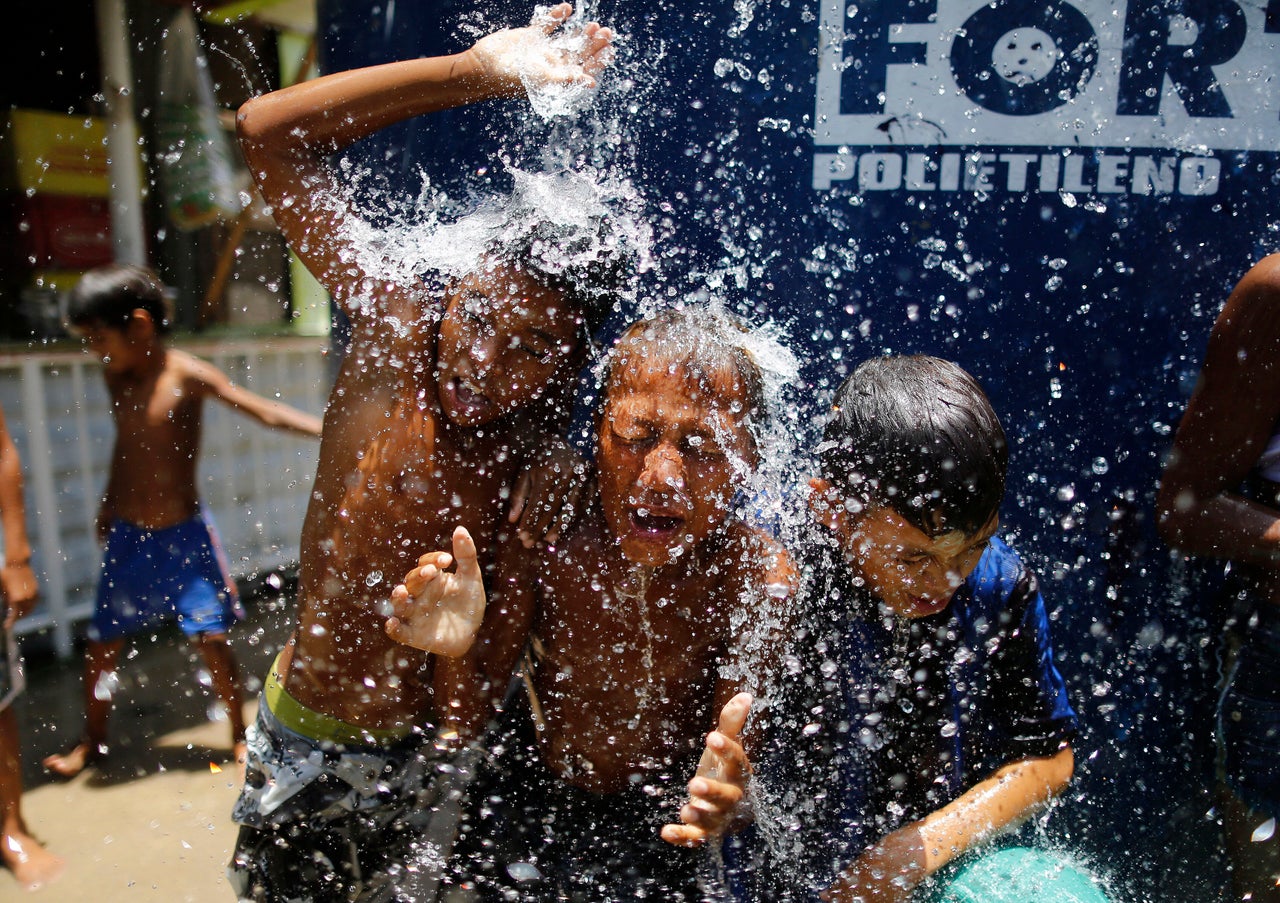 Children play under the water from a water tank at the Alemao Complex neighborhood in Rio de Janeiro in January 2015. According to state environment secretary Andre Correa, the region was “experiencing the worst water crisis in its history.”