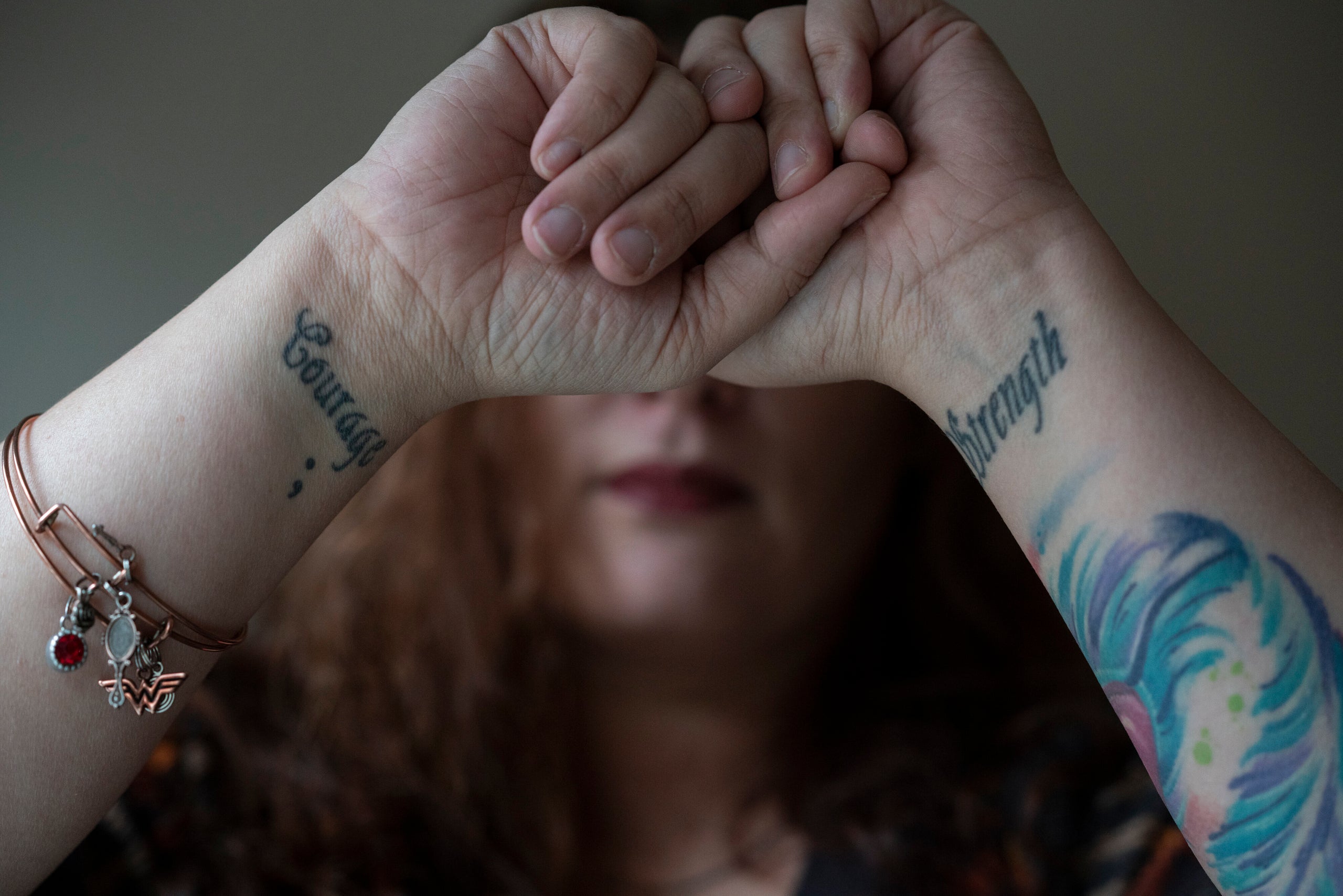  Before leaving her ex-husband she got tattoos on her wrists with the words "Strength" and "Courage" to remind herself,