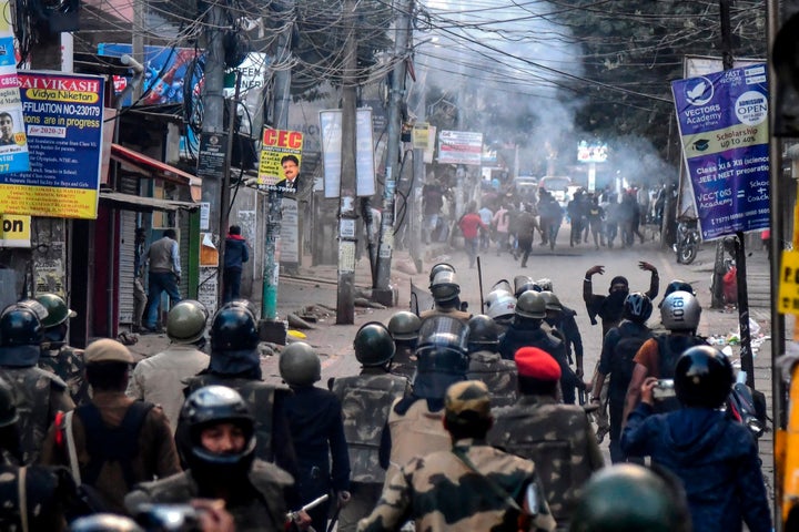 Demonstrators shout slogans as police fire tear gas during a protest against the government's Citizenship Amendment Bill (CAB) in Guwahati on December 12, 2019. 