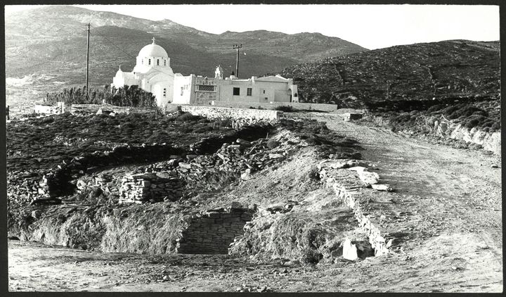Άποψη της ανασκαφής στην Αγία Θέκλα, στην Τήνο, το 1979. Διακρίνονται υπολείμματα του θολωτού τάφου (κάτω) και η ομώνυμη εκκλησία (πάνω)