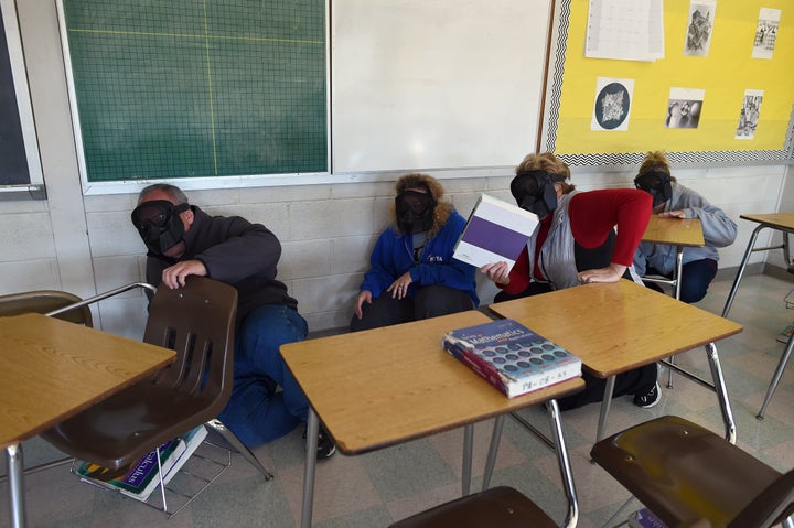 Participants hide from an "active shooter" during ALICE training at the Harry S Truman High School in Levittown, Pennsylvania, on November 3, 2015.