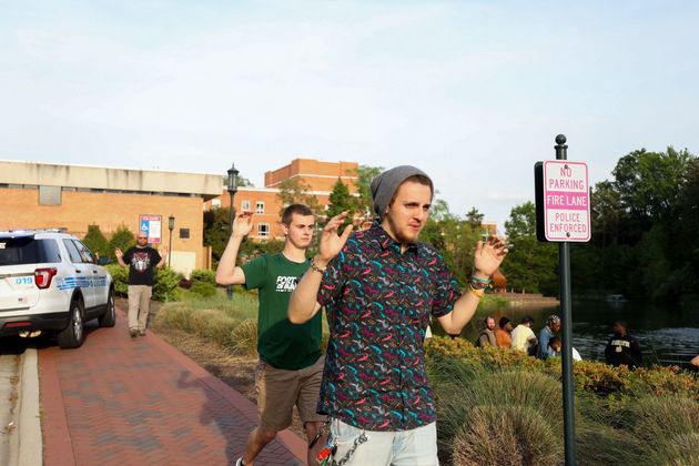 Students and faculty file out of buildings with their hands up during a lockdown after a shooting on the campus of University of North Carolina Charlotte in University City, Charlotte, on April 30, 2019. Six people were shot and two died.