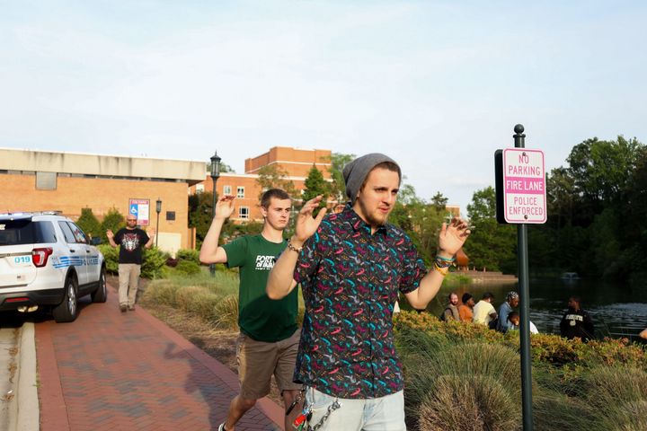 Students and faculty file out of buildings with their hands up during a lockdown after a shooting on the campus of University of North Carolina Charlotte in University City, Charlotte, on April 30, 2019. Six people were shot and two died.