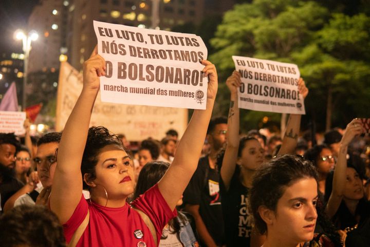 A woman holds a paper that reads "I fight, you fight, we defeat Bolsonaro!" during a protest in São Paulo, Brazil, October 31, 2019.