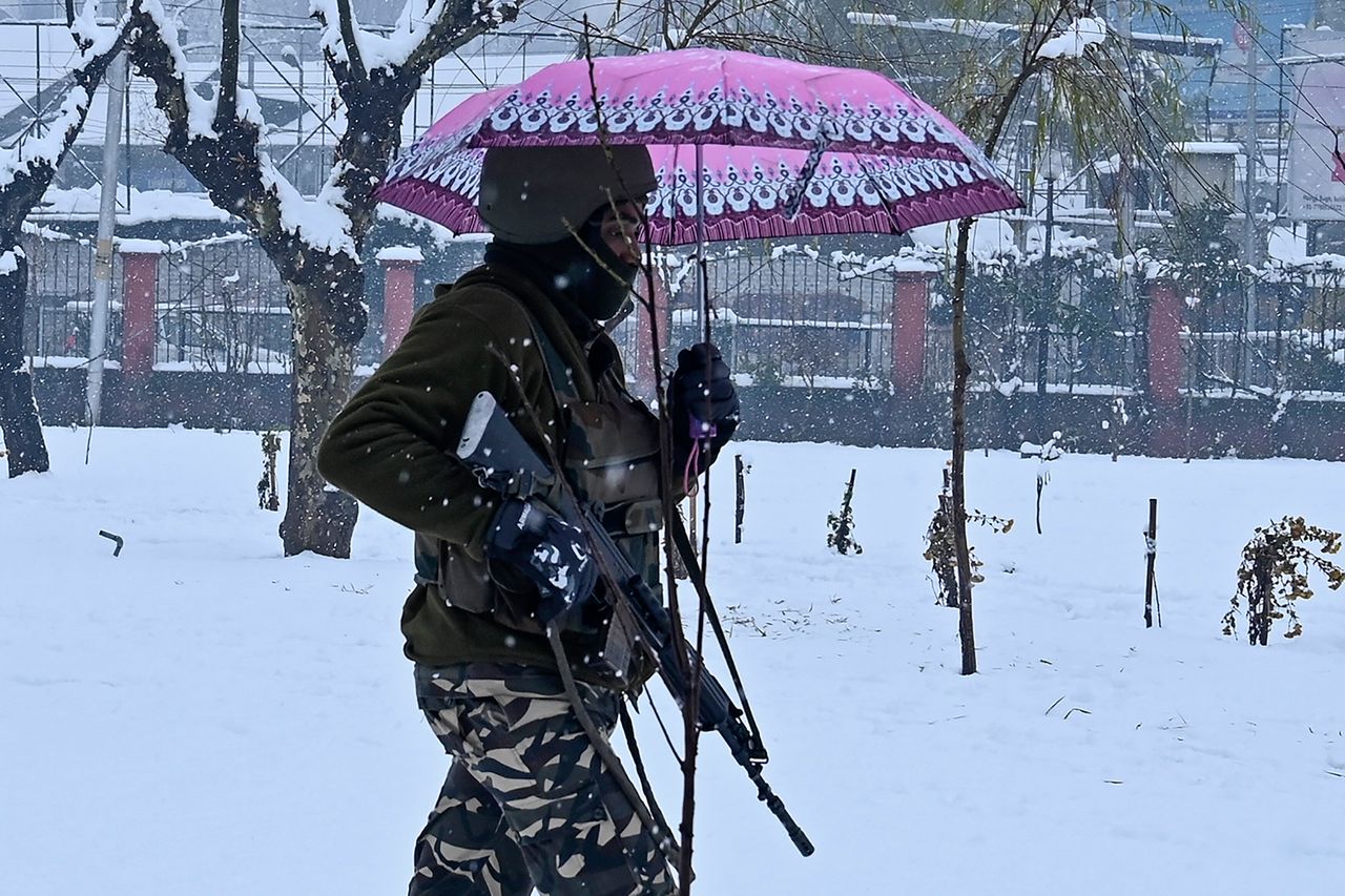 Την Δευτέρα, ένας Ινδός παραστρατιωτικός, περπατάει κατά την διάρκεια χιονόπτωσης, στο πάρκο Σριναγκάρ, κρατώντας μία ομπρέλα.
