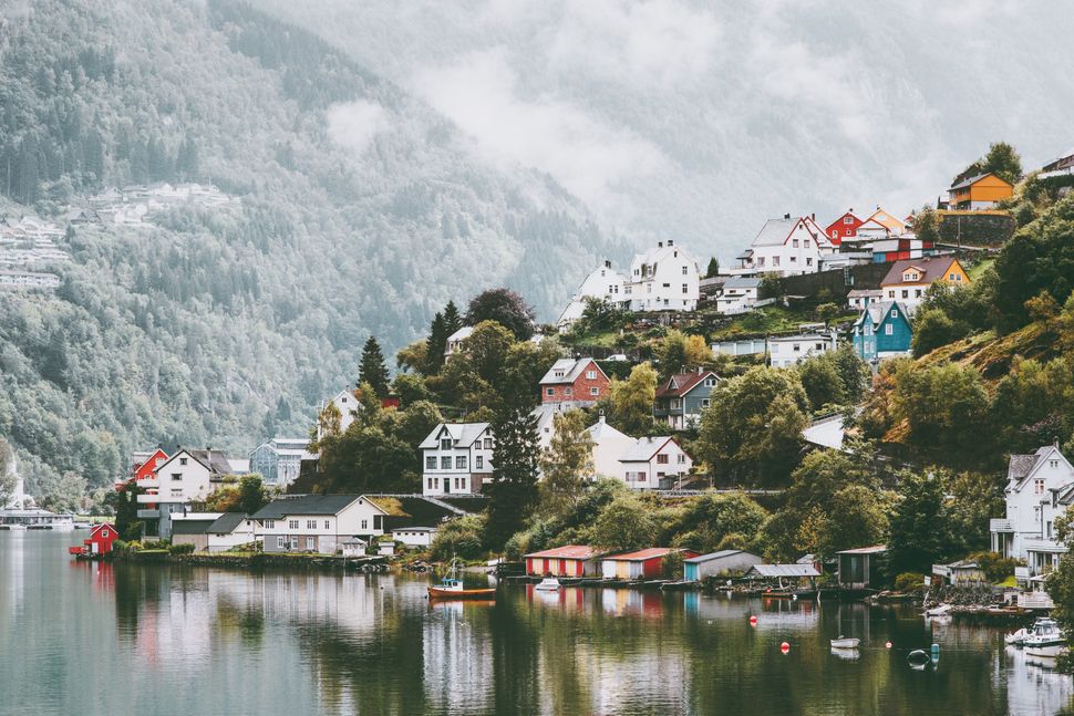 Odda city houses in Norway Landscape foggy mountains and water reflection