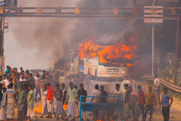 Protesters block a road after setting buses on fire during a demonstration against the Citizenship Act in Howrah, on the outskirts of Kolkata on December 14, 2019.