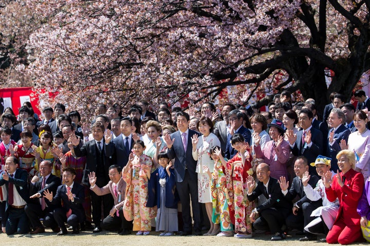 TOKYO, JAPAN - APRIL 13: Japan's Prime Minister Shinzo Abe (C-L) and his wife Akie (C-R) pose for photographs with guest attendees during the cherry blossom viewing party at the Shinjuku Gyoen National Garden on April 13, 2019 in Tokyo, Japan. (Photo by Tomohiro Ohsumi/Getty Images)