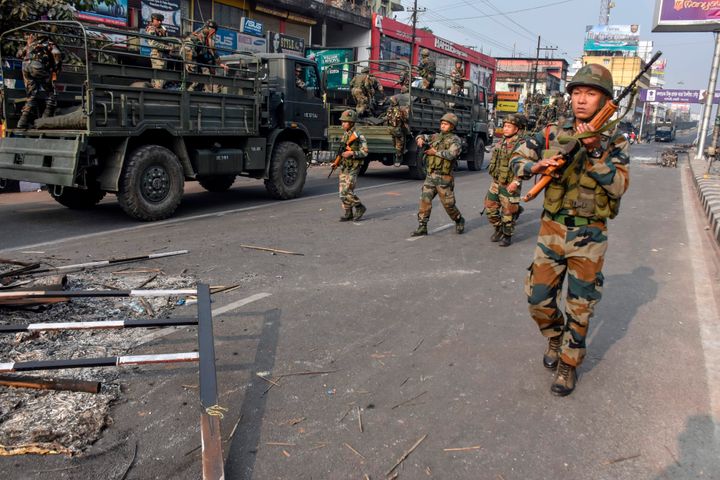 Indian soldiers patrol near the burnt wreckage of a vehicle during a curfew in Guwahati on December 12, 2019, following protests over the government's Citizenship Amendment Bill. Authorities deployed thousands of paramilitaries and blocked mobile internet in northeast India on December 12, while police fired blank rounds at protesters who defied a curfew to demonstrate against contentious new citizenship legislation. The curfew was on Sunday relaxed for a few hours in some parts. 