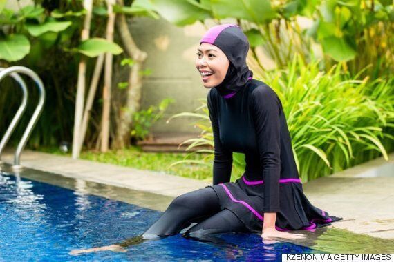 ブルキニ姿で水泳プールでくつろぐイスラム教徒の女性