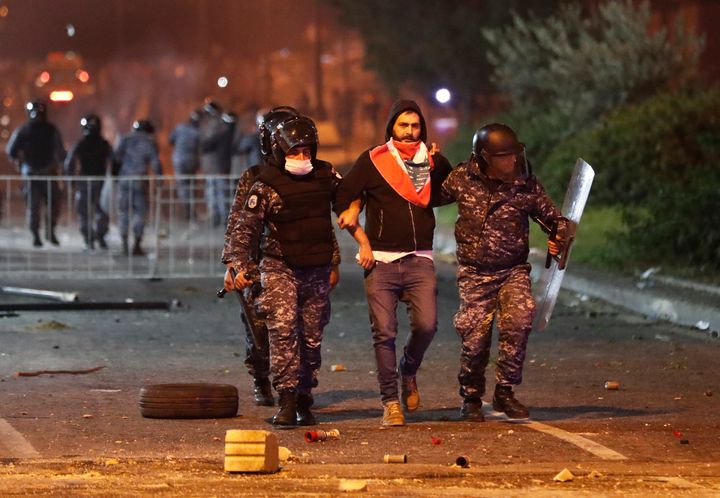 Riot police officers arrest an anti-government protester during a protest near the parliament square in downtown Beirut, Leba