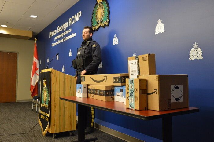Cst. Brent Benbow stands next to Amazon packaging as he speaks to media in Prince George, B.C.