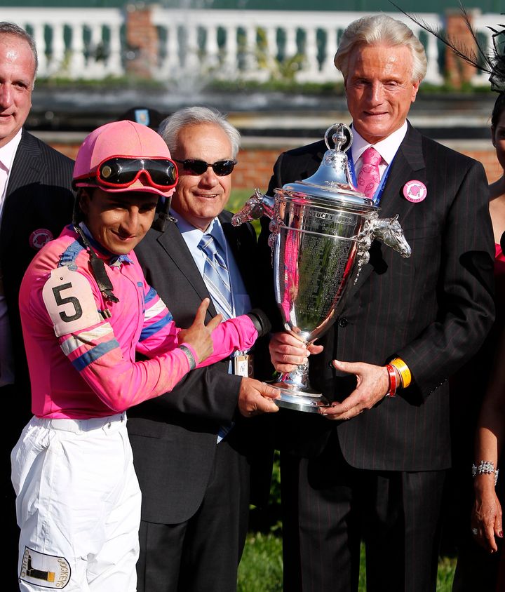 Trainer Jerry Hollendorfer is seen (center) holding the Oaks trophy after his horse Blind Luck won at Churchill Downs in Louisville, Kentucky, in 2010.