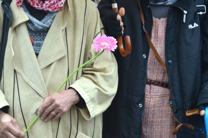 花を手にするフラワーデモの参加者＝11月18日、長崎市