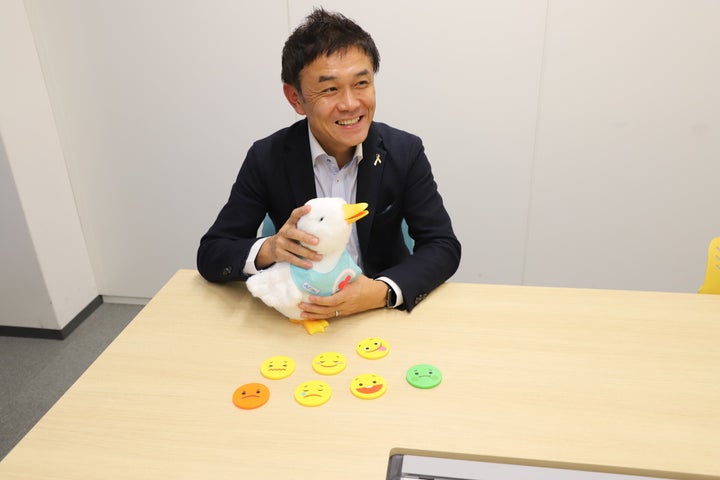 小児がんの子どもたちに贈ったアヒル型ロボット「My Special Aflac Duck（マイ スペシャル アフラック ダック）」を抱える、アフラック社会公共活動推進室長の辻田毅（つじた・たけし）さん