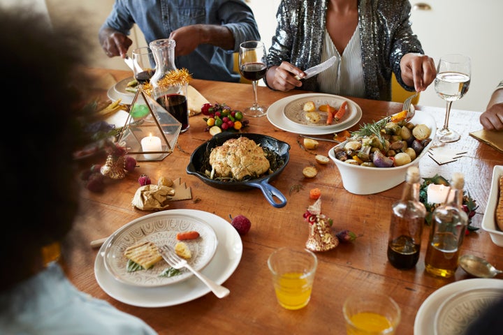 Midsection of couple having lunch on dining table at home during Christmas festival