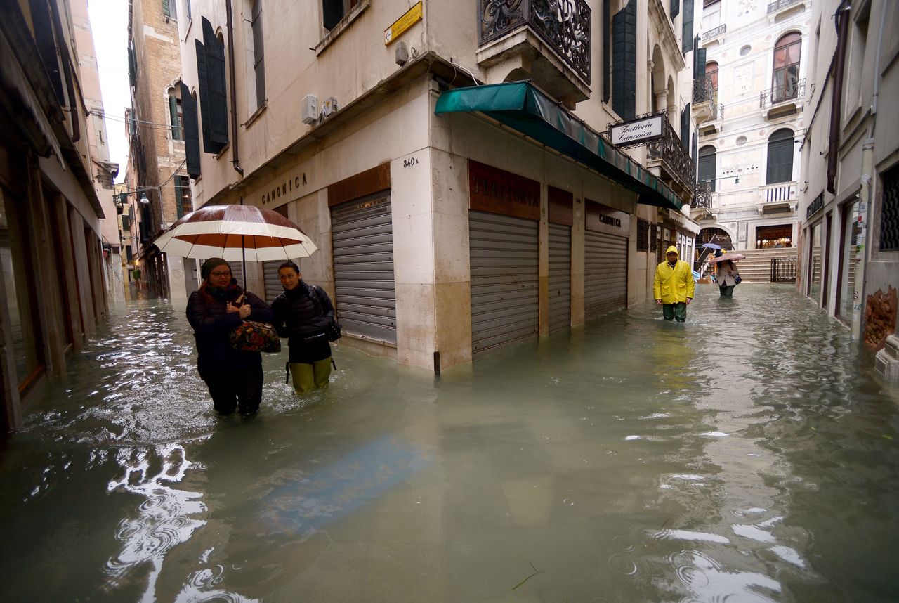 People walk across flooded streets on Nov. 15, 2019 in Venice, two days after the city suffered its highest tide in 50 years.
