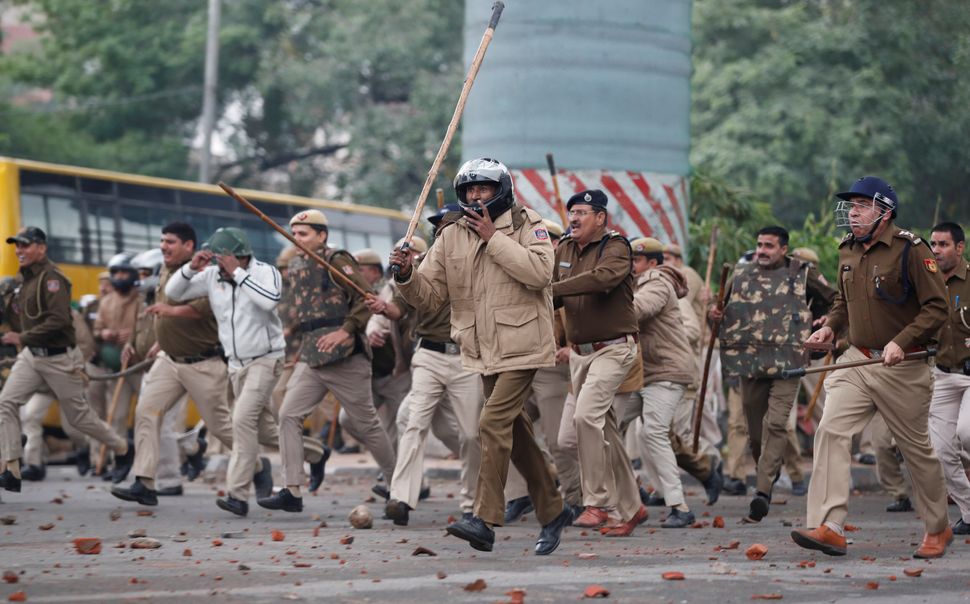 Police officers chase protestors during a protest against the Citizenship Amendment Bill, a bill that seeks to give citizenship to religious minorities persecuted in neighbouring Muslim countries, outside the Jamia Millia Islamia University in New Delhi, India, December 13, 2019. REUTERS/Adnan Abidi