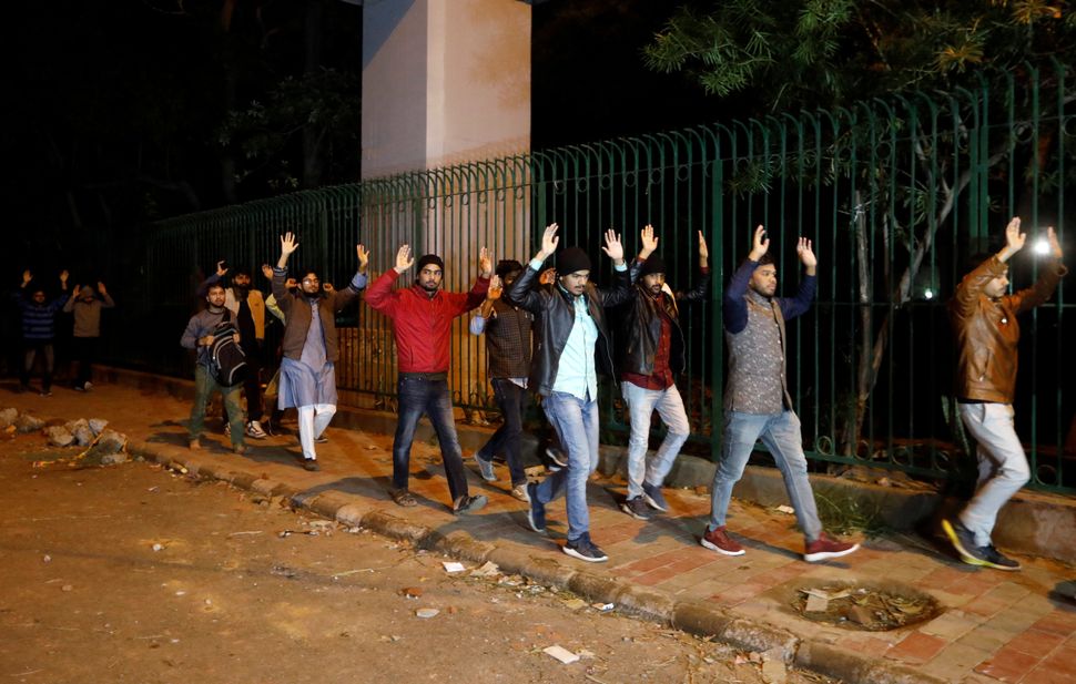 Students raising their hands leave the Jamia Milia University following a protest against a new citizenship law, in New Delhi, India, December 15, 2019. 