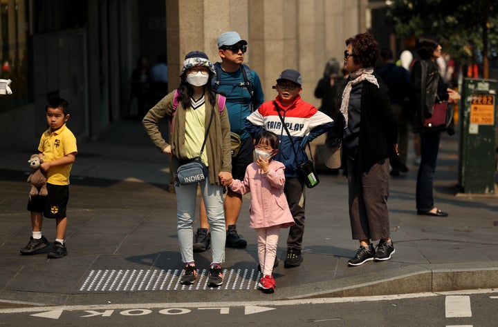 A family wear face masks as protection from the smoke haze in Sydney, Australia. 