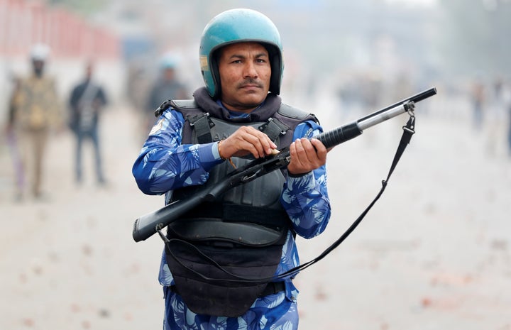 A riot police officer loads a rifle during a protest against a new citizenship law in Seelampur, area of Delhi, India December 17, 2019. REUTERS/Adnan Abidi