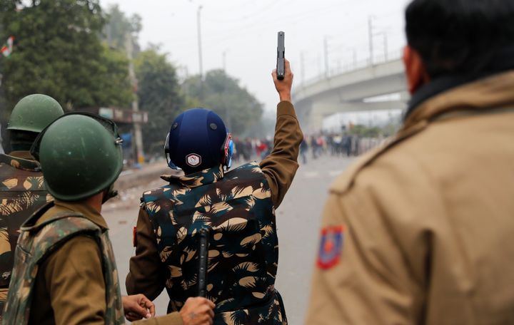 A riot police officer holds a gun during a protest against a new citizenship law in Seelampur, area of Delhi, India December 17, 2019. REUTERS/ Danish Siddiqui