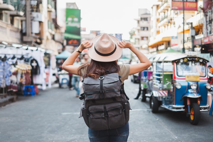 Back view Asian woman tourist backpacker travel in Khao San road, Bangkok, Thailand