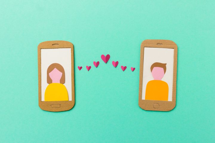 Online dating and mobile flirting concept - man and woman profile on smartphones connected with flying paper hearts