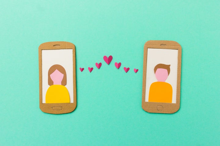 Online dating and mobile flirting concept - man and woman profile on smartphones connected with flying paper hearts