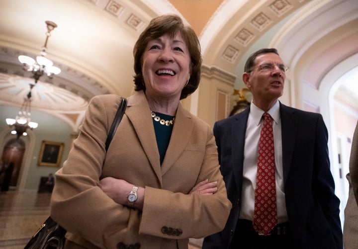 Sen. Susan Collins, R-Maine, joined by Sen. John Barrasso, R-Wyo., smiles as the Senate passed a resolution to terminate Pres