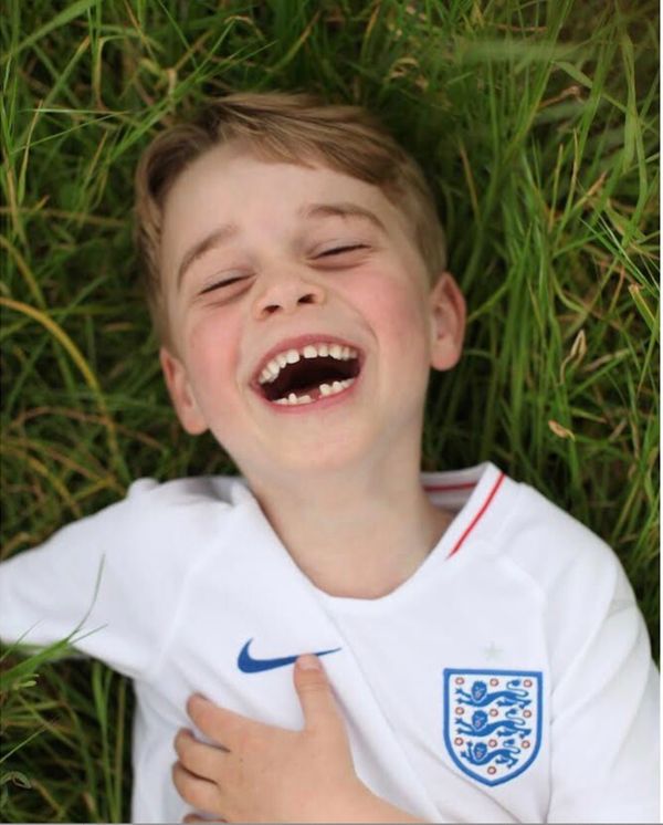 Prince George laughs in the garden of his home at Kensington Palace in this photo released ahead of his sixth birthday in Jul