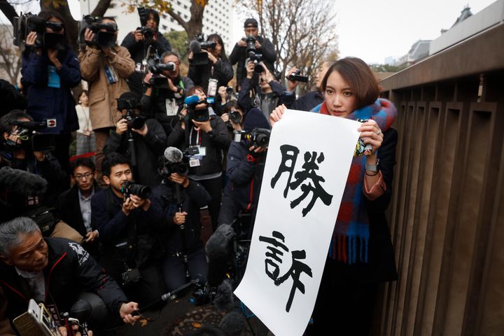 Freelance journalist Shiori Ito holds a banner that reads in English "winning the lawsuit" during a news conference outside a courthouse Wednesday, Dec. 18, 2019, in Tokyo. A Tokyo court awarded compensation to Ito in a high-profile rape case which prosecutors had once dropped their criminal investigation into an alleged attacker known for his close ties with Prime Minister Shinzo Abe and his ultra-conservative supporters. (AP Photo/Jae C. Hong)