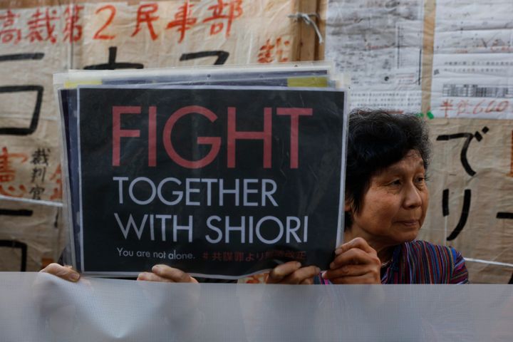 Two supporters of freelance journalist Shiori Ito hold signs outside a courthouse Wednesday, Dec. 18, 2019, in Tokyo. A Tokyo court awarded compensation to Ito in a high-profile rape case which prosecutors had once dropped their criminal investigation into an alleged attacker known for his close ties with Prime Minister Shinzo Abe and his ultra-conservative supporters. (AP Photo/Jae C. Hong)