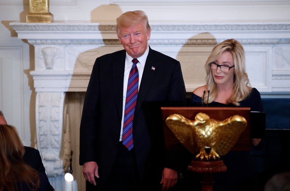 Trump smiles as Paula White prepares to lead the room in prayer during a dinner for evangelical leaders in the State Dining R