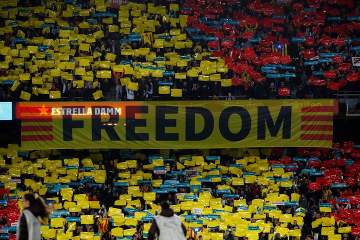 Una de las grandes pancartas y multitud de pequeñas con la leyenda 'Spain, sit and talk' en el Camp Nou