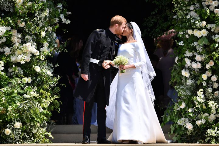 The newly-minted Duke and Duchess of Sussex kiss outside of St. George's Chapel on the day of their wedding.