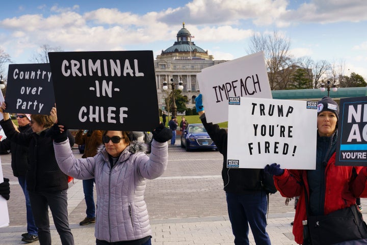 Protesters greet lawmakers as the Democratic-controlled House of Representatives debates impeachment charges against Presiden
