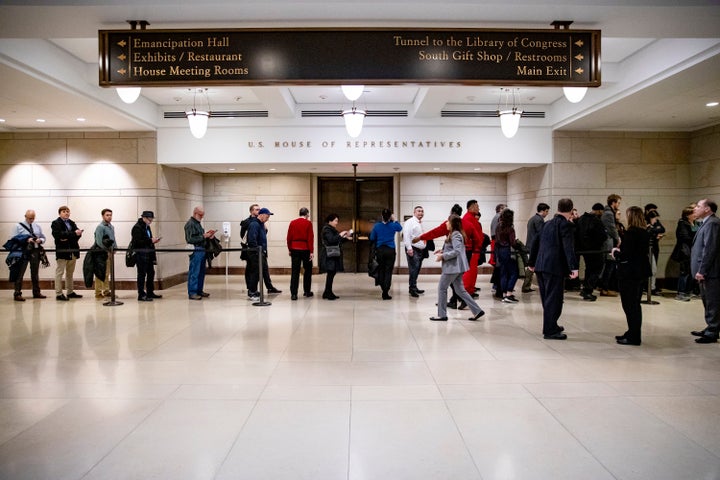 Tourists wait in line for a chance to get into the House chamber to watch lawmakers vote to impeach President Donald Trump.