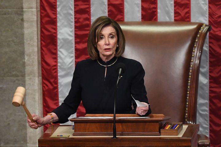 Pelosi presided over the House as votes were cast on two articles of impeachment. (Photo by SAUL LOEB/AFP via Getty Images)