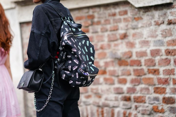 An attendee at Milan Fashion Week wearing a Moschino backpack and a Chanel purse on Sept. 20, 2019.&nbsp;