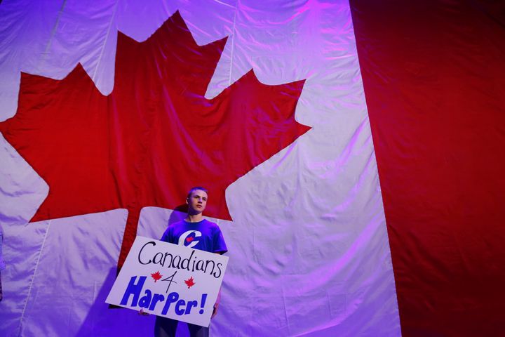A young conservative waits for Prime Minister Stephen Harper to enter at the conservative election headquarters in Calgary on Oct. 19, 2015.