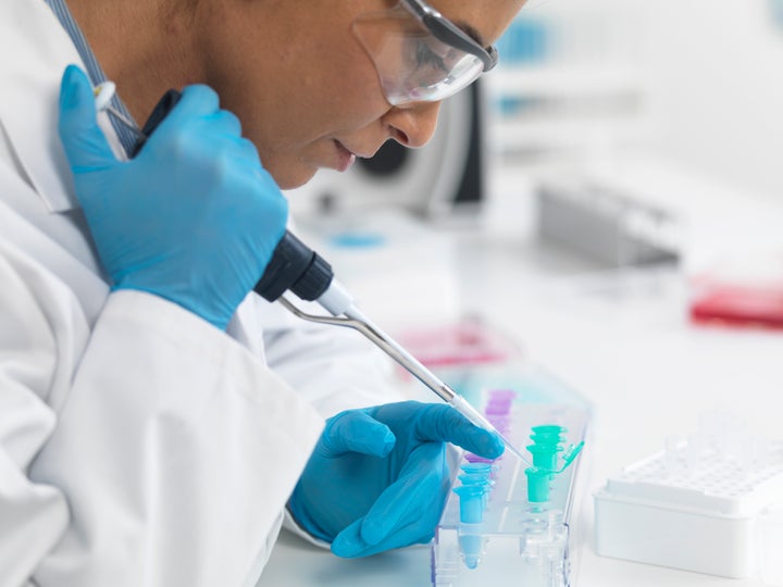 Female scientist pipetting DNA samples for testing